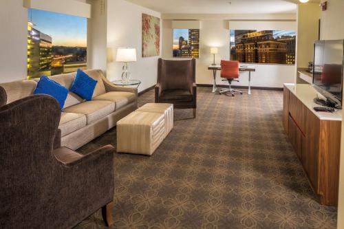a living room with a couch and a tv at DoubleTree by Hilton Hotel & Suites Pittsburgh Downtown in Pittsburgh