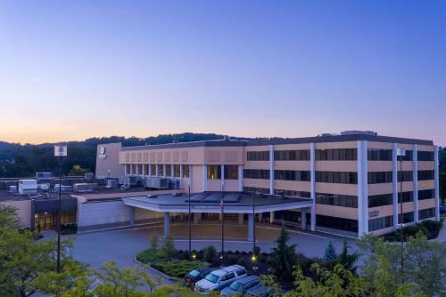 a large building with cars parked in a parking lot at DoubleTree by Hilton Pittsburgh - Cranberry in Cranberry Township