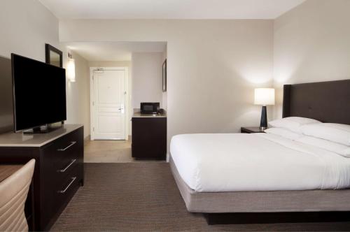 a hotel room with a bed and a flat screen tv at Hilton Santa Cruz Scotts Valley in Santa Cruz