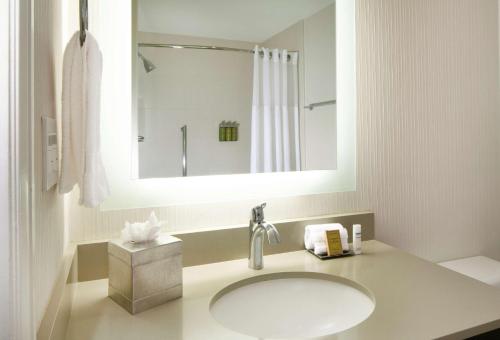 a white bathroom with a sink and a mirror at Hilton Santa Cruz Scotts Valley in Santa Cruz