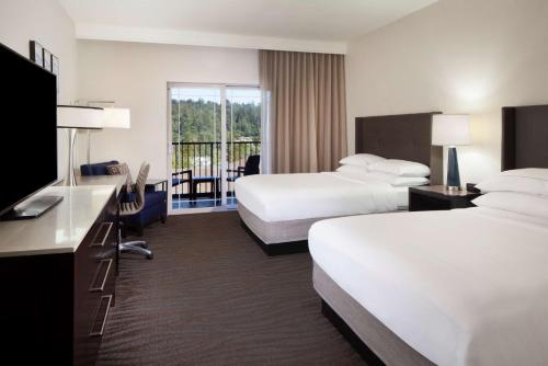 a hotel room with two beds and a flat screen tv at Hilton Santa Cruz Scotts Valley in Santa Cruz