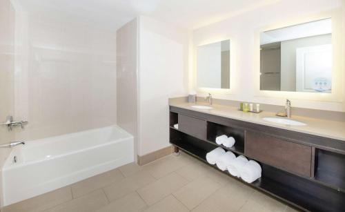 a bathroom with a tub and a sink and a bath tub at Hilton Santa Cruz Scotts Valley in Santa Cruz