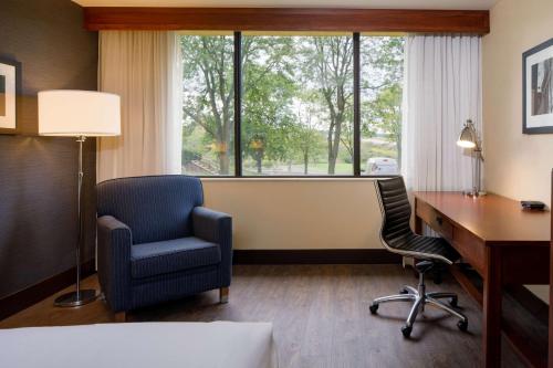 a hotel room with a desk and chairs and a window at DoubleTree by Hilton Pittsburgh - Cranberry in Cranberry Township
