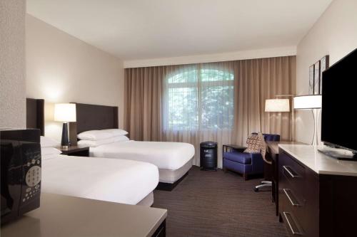 a hotel room with two beds and a tv at Hilton Santa Cruz Scotts Valley in Santa Cruz
