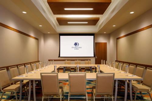 a conference room with tables and chairs and a screen at DoubleTree by Hilton Pittsburgh - Cranberry in Cranberry Township
