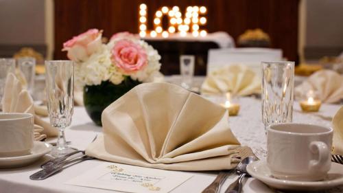 a table with a white table cloth with glasses and napkins at DoubleTree by Hilton Pittsburgh - Cranberry in Cranberry Township