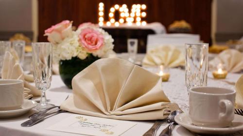 a table with a white table cloth with napkins and glasses at DoubleTree by Hilton Pittsburgh - Cranberry in Cranberry Township