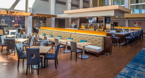 a restaurant with tables and chairs and a bar at DoubleTree by Hilton Pittsburgh - Cranberry in Cranberry Township