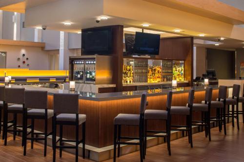 a bar with a bunch of chairs in a room at DoubleTree by Hilton Pittsburgh - Cranberry in Cranberry Township