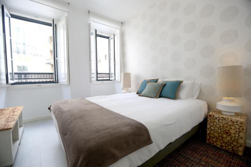 リスボンにあるEnjoy Lisbon Graçaの白いベッドルーム(青い枕の大型ベッド付)