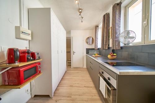 a kitchen with a red appliance on a counter at Le Salengro - Studio cosy - métro Charpennes in Villeurbanne