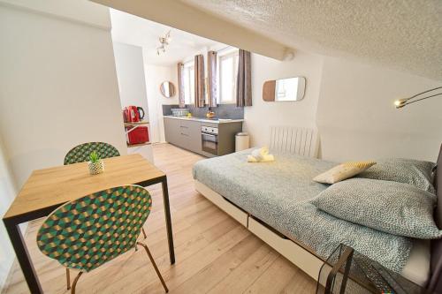 a bedroom with a bed and a table and chairs at Le Salengro - Studio cosy - métro Charpennes in Villeurbanne