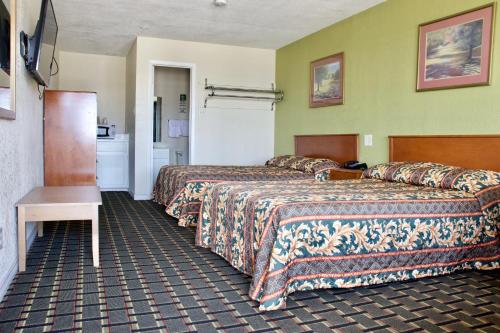 a hotel room with two beds and a table at Executive Inn of Arlington, Near AT&T Stadium in Arlington