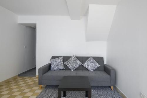 ein Wohnzimmer mit einer grauen Couch mit Kissen in der Unterkunft Charming house in Faches-Thumesnil - Welkeys in Faches-Thumesnil