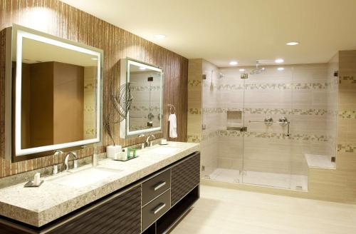 a bathroom with a large mirror and a shower at Hilton Orange County/Costa Mesa in Costa Mesa