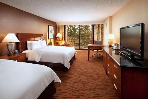 a hotel room with two beds and a flat screen tv at Hilton Orange County/Costa Mesa in Costa Mesa