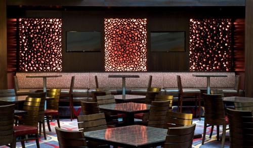a restaurant with tables and chairs and a bar at Embassy Suites by Hilton Dulles Airport in Herndon
