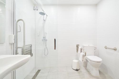 a white bathroom with a shower and a toilet at Hotel Torre Del Conde in San Sebastián de la Gomera