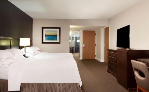 a hotel room with two beds and a flat screen tv at Hilton Houston NASA Clear Lake in Seabrook
