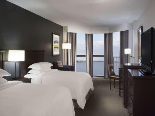 a hotel room with two beds and a flat screen tv at Hilton Houston NASA Clear Lake in Seabrook
