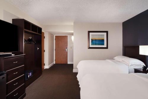 a hotel room with two beds and a flat screen tv at Hilton Houston NASA Clear Lake in Seabrook
