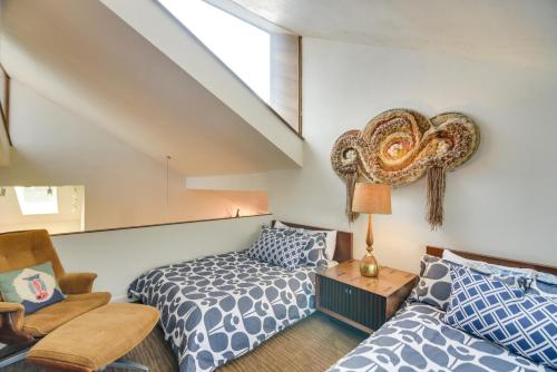 a attic bedroom with a bed and a chair at Luxe Boulder Barrett House on Mtn Peak with Hot Tub in Boulder