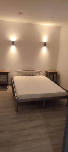 Cette chambre comprend un grand lit et 2 tables. dans l'établissement meublé neuf avec jardin, à Clairvaux-les-Lacs