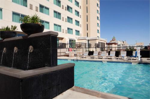 a swimming pool with a fountain in front of a building at DoubleTree by Hilton El Paso Downtown in El Paso