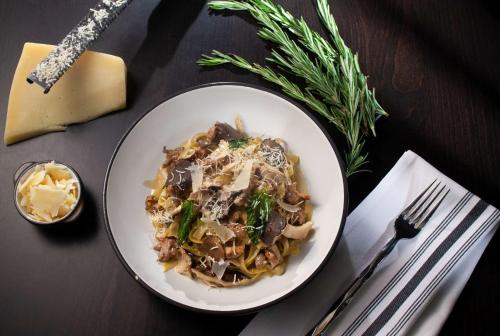 a plate of pasta with mushrooms and cheese on a table at DoubleTree by Hilton El Paso Downtown in El Paso