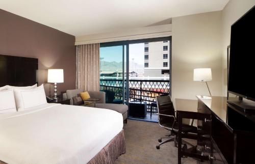 a hotel room with a bed and a desk and a balcony at DoubleTree by Hilton El Paso Downtown in El Paso