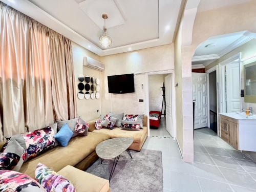 sala de estar con sofá y TV en Al Hanae Family Aparts, en Marrakech