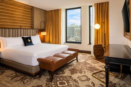 a hotel room with a bed and a desk at The Peregrine Omaha Downtown Curio Collection By Hilton in Omaha