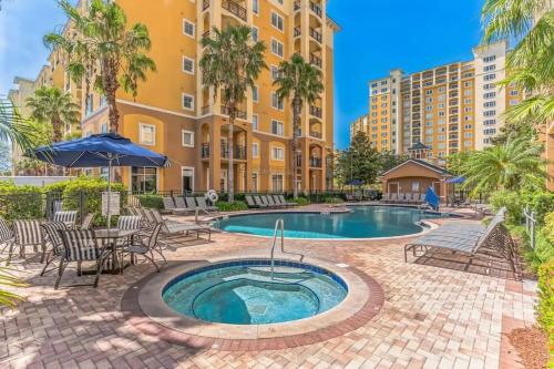 um pátio com piscina e cadeiras e um edifício em Elegant Condo Retreat Near Disney em Orlando