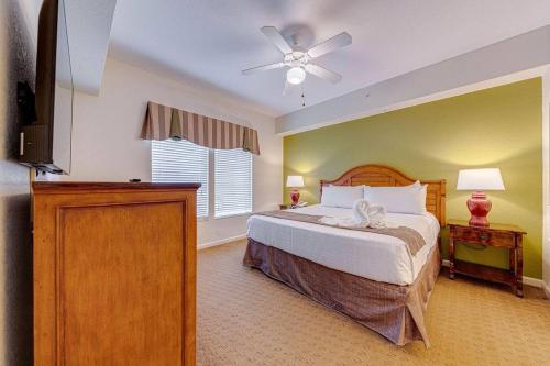 um quarto com uma cama e uma ventoinha de tecto em Elegant Condo Retreat Near Disney em Orlando