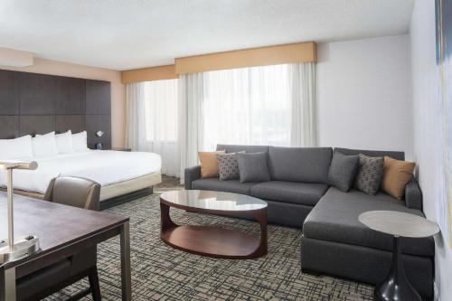 Habitación de hotel con sofá y cama en DoubleTree by Hilton Hotel Syracuse, en East Syracuse