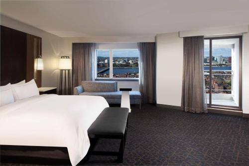 a hotel room with a bed and a chair and windows at Hilton Boston Back Bay in Boston