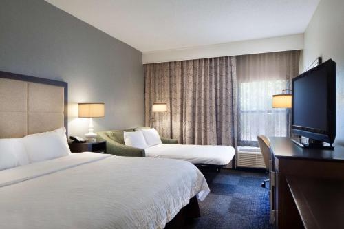 um quarto de hotel com uma cama e uma televisão em Hampton Inn Lawrenceville em Lawrenceville