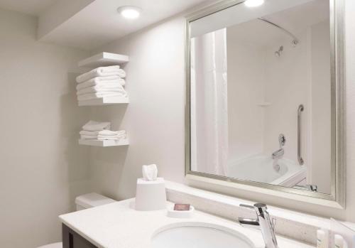a white bathroom with a sink and a mirror at Hampton Inn Charleston-Southridge in Charleston