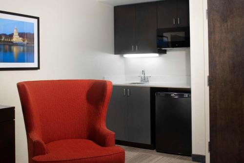 a kitchen with a red chair and a sink at Hampton Inn Charleston-Southridge in Charleston