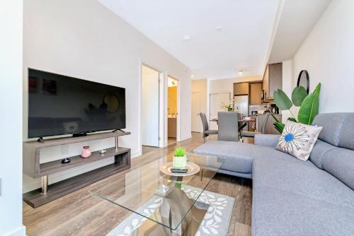 uma sala de estar com uma grande televisão de ecrã plano em Luxurious 1BR Condo - Stunning City Views em Kitchener