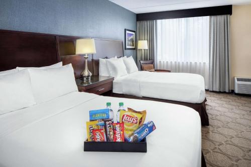 two beds in a hotel room with snacks and chips at DoubleTree by Hilton Hotel Cleveland - Independence in Independence