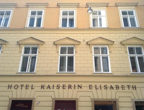 a building with two windows and a sign on the side of it at Hotel Kaiserin Elisabeth in Vienna
