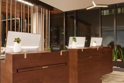 dos jarrones blancos sobre armarios de madera en Embassy Suites By Hilton Boulder en Boulder