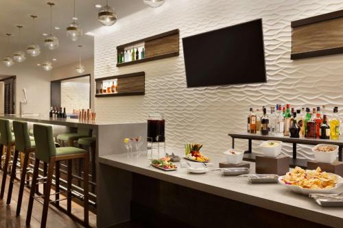 a restaurant with a bar with food on a counter at Embassy Suites By Hilton Boulder in Boulder