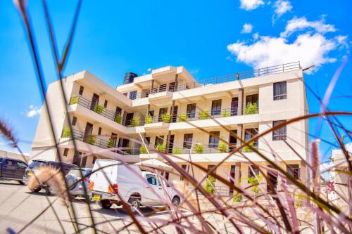 a building with a van parked in front of it at Walabi Mara Hotel in Narok