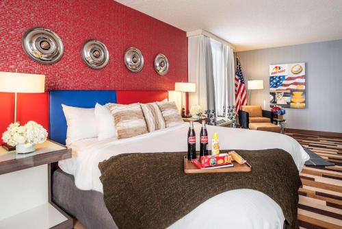 a bedroom with a large bed with a red wall at the Curtis Denver - A DoubleTree by Hilton Hotel in Denver