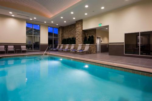 a large swimming pool in a hotel with chairs at Embassy Suites by Hilton Denver Downtown Convention Center in Denver