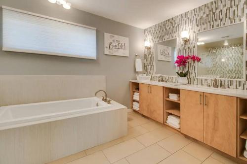 uma casa de banho com uma banheira e um espelho grande em Spacious home w/ Beautiful Views and Heated Pool em Fountain Hills