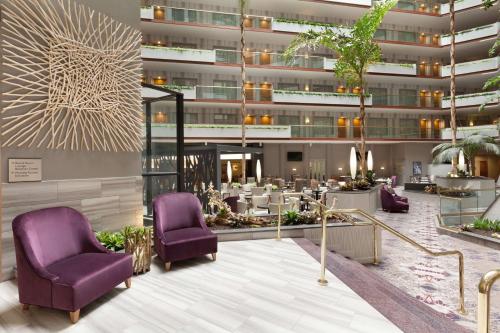 a lobby of a hotel with purple chairs and tables at Embassy Suites by Hilton Irvine Orange County Airport in Irvine
