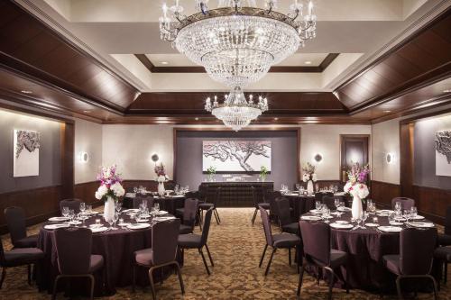 a ballroom with tables and chairs and a chandelier at The Logan Philadelphia, Curio Collection by Hilton in Philadelphia